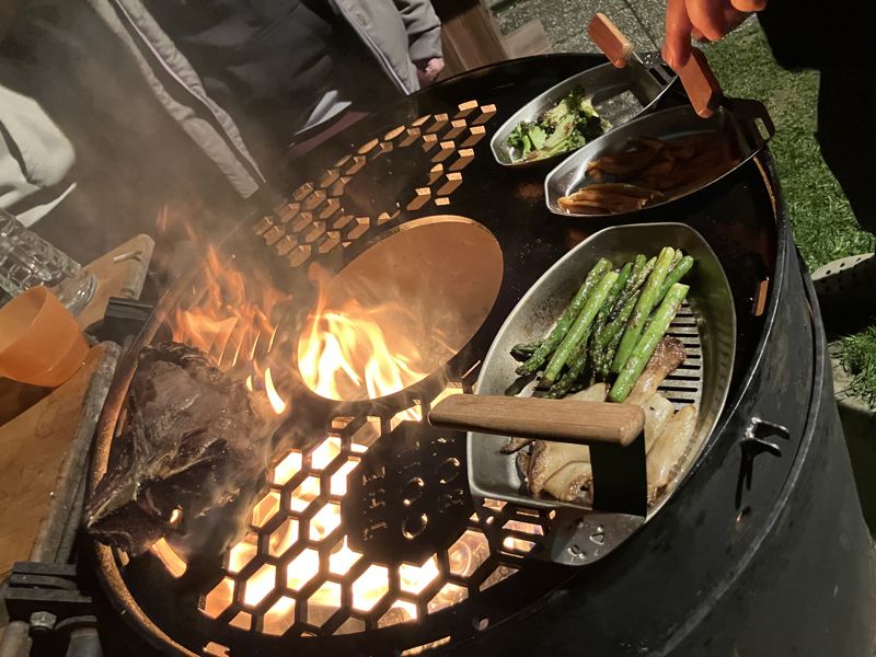 Grillplatte mit Gemüseschalen und Feuer